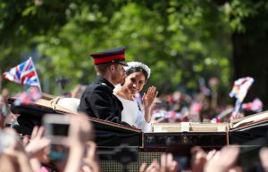 Prince Harry, Duke of Sussex and his wife Meghan, Duchess of Sussex wave from the Ascot Landau Carriage during their carriage procession on the Long Walk as they head back towards Windsor Castle.